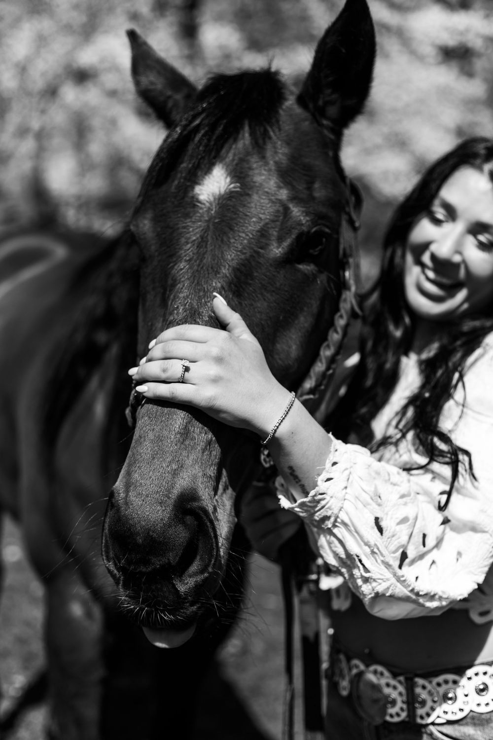 An intimate black and white portrait of a horse and rider sharing a tender moment.