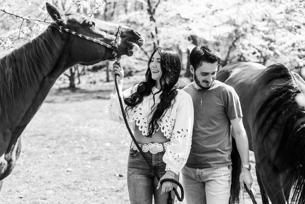 A lovely outdoor moment with a couple and their horse enjoying a sunny day in the woods.