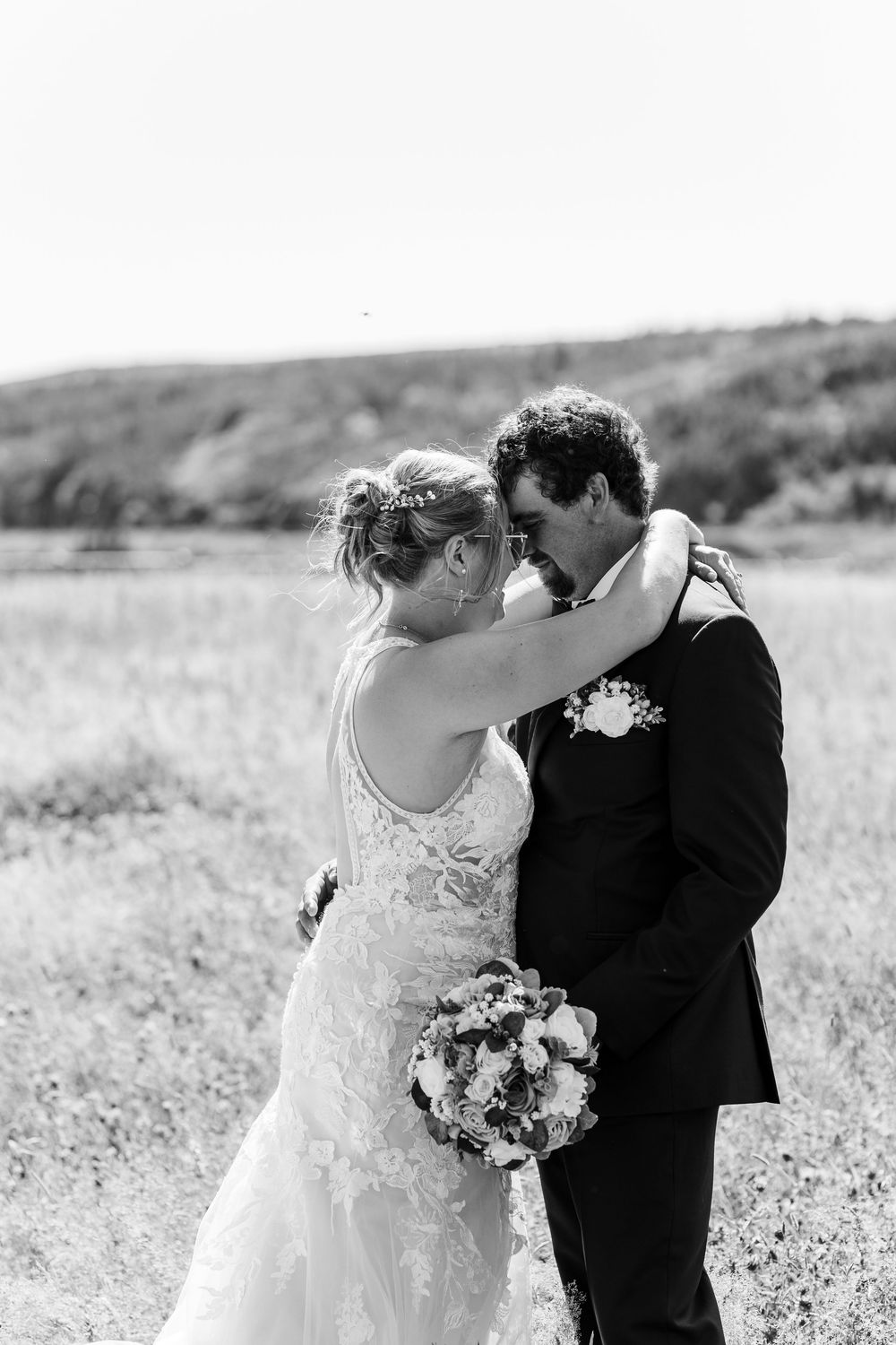 A romantic series of black and white wedding photos showing intimate moments between newlyweds in a field.