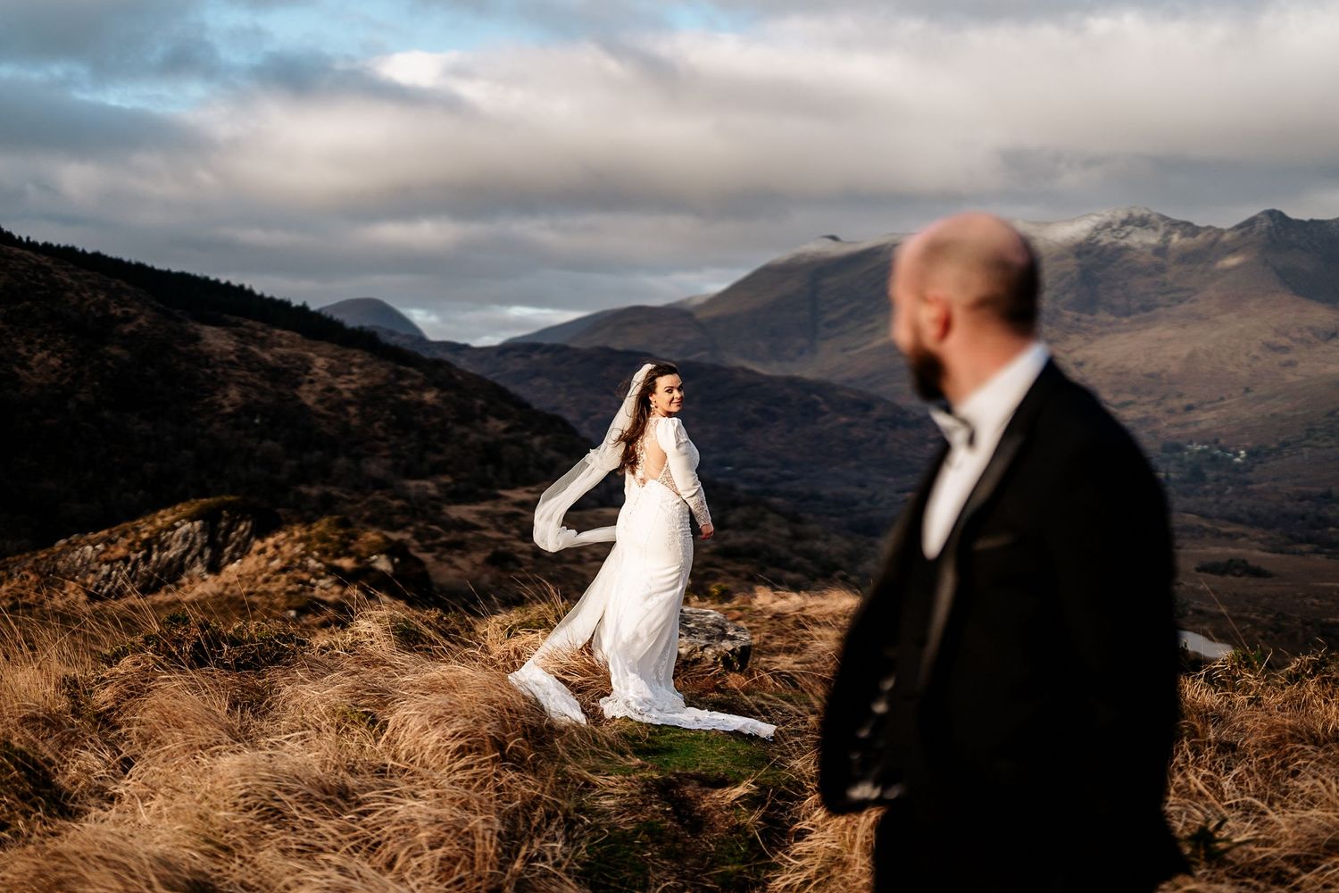 A scenic mountain wedding photography session with dramatic clouds and rugged landscape.