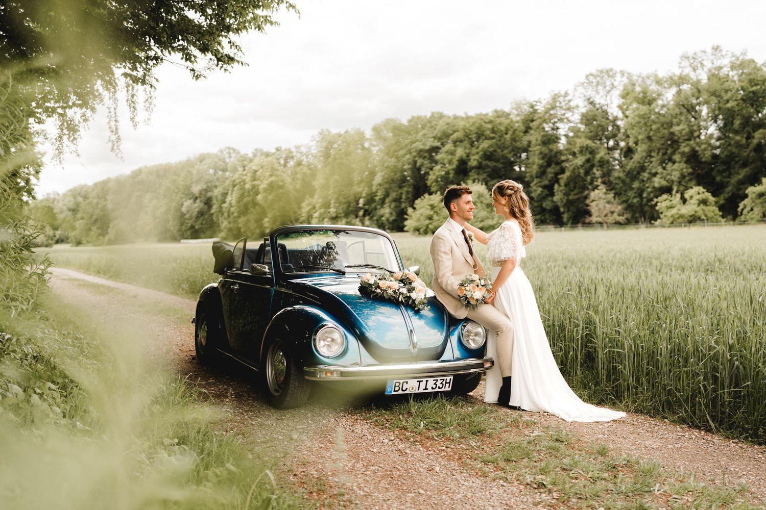 Brautpaar auf einen Feldweg mit einem blauen VW-Käfer bei Äpfingen in der Gemeinde Maselheim - Hochzeitsfotografie Ramona Maier