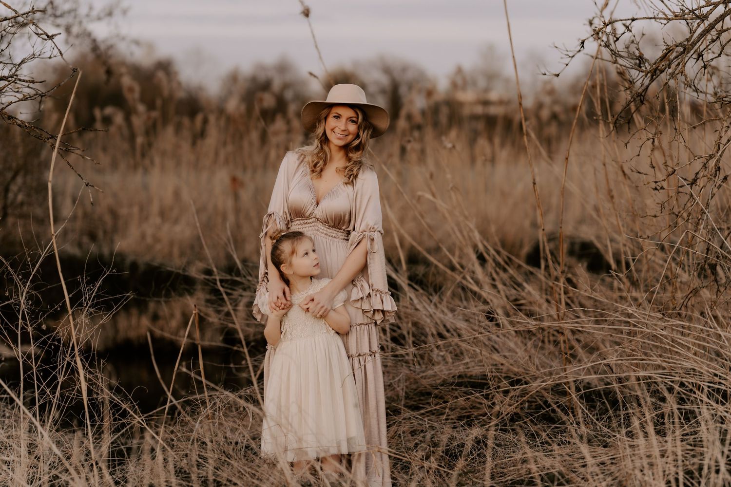 A dreamy golden-hour portrait in a rustic field with natural grasses and soft autumn lighting.