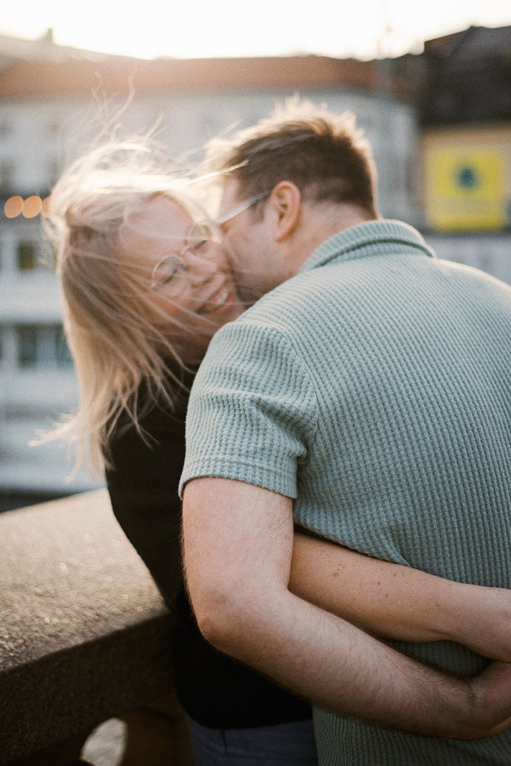 A romantic embrace between two people in the sunlight, with long hair blowing in the breeze.