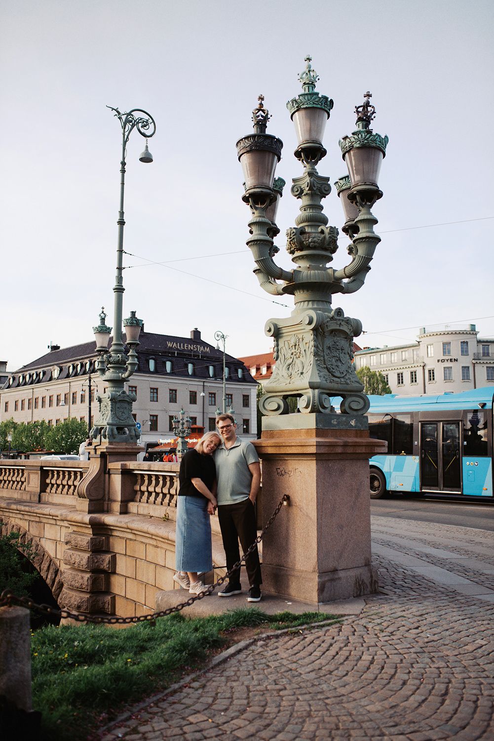 Ornate historical lamp post and stone bridge in Gothenburg, Sweden with a decorative multi-armed street light and cobblestone path.