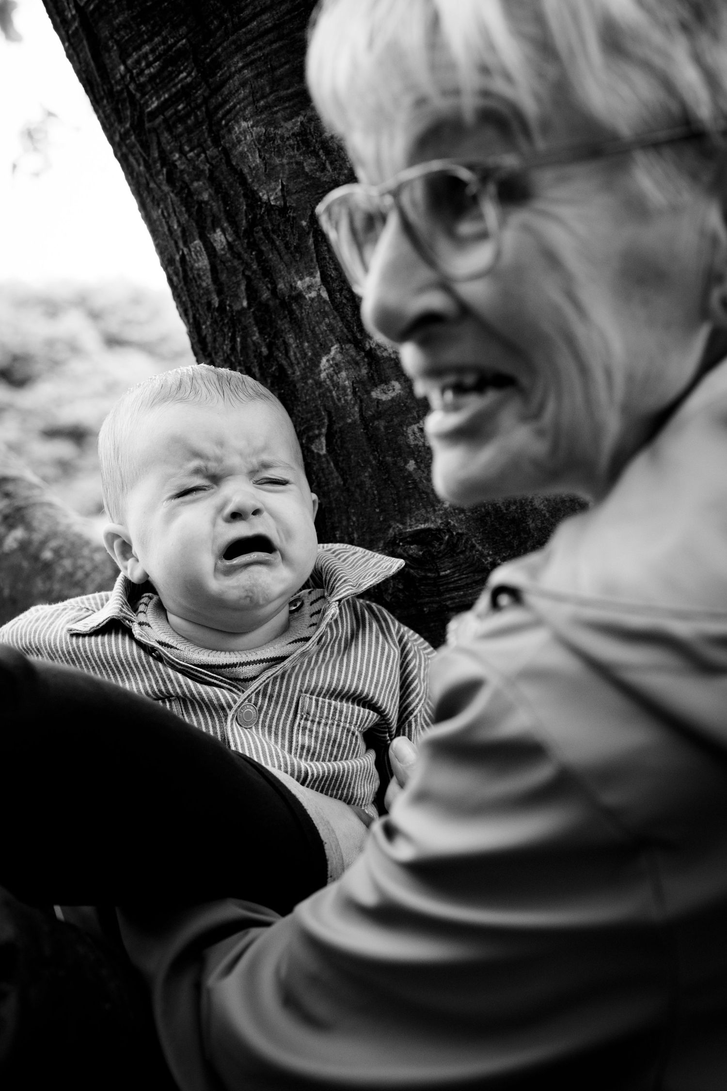 Black and white photograph showing emotional interaction between elder and infant.
