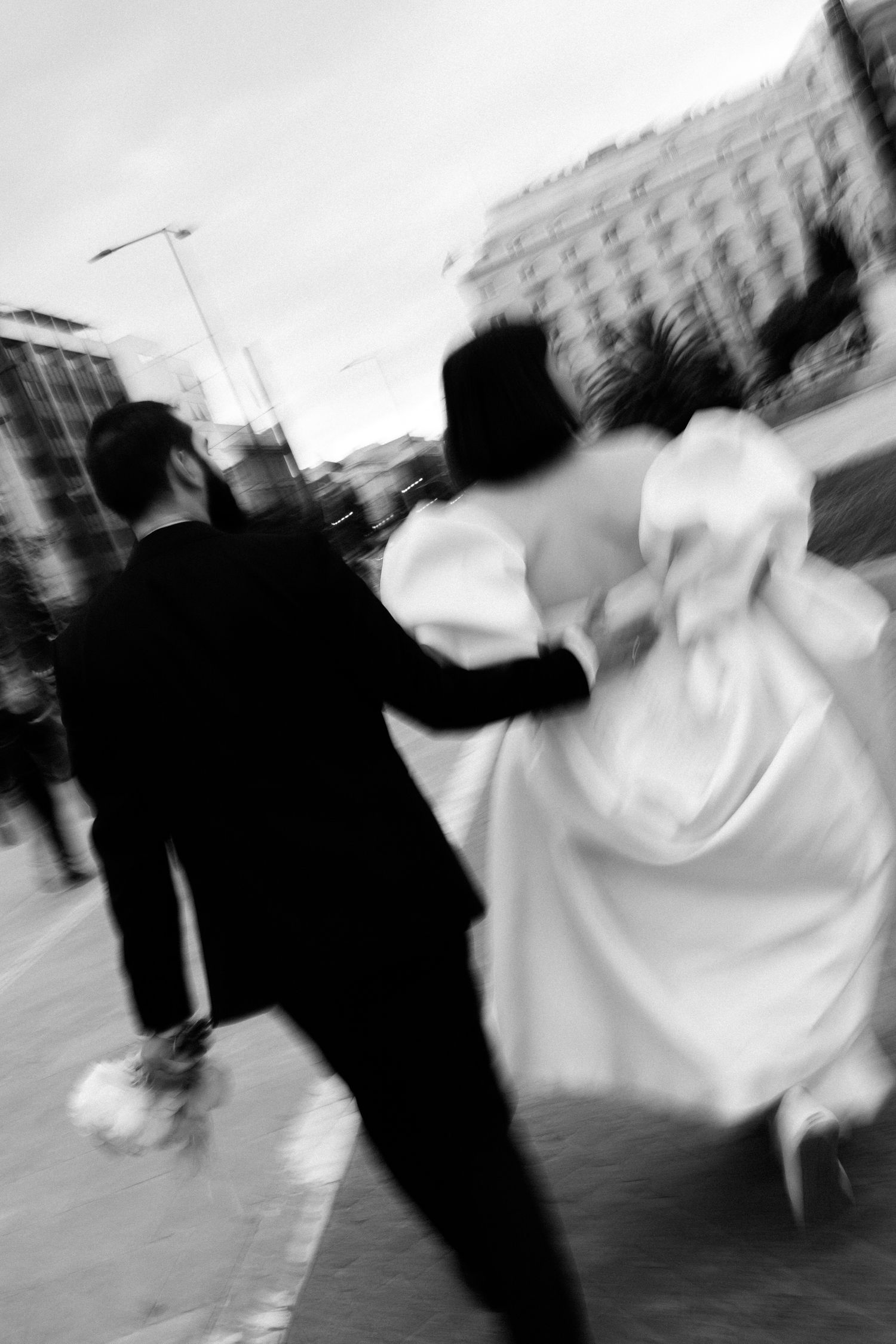 Motion-blurred photo of couple walking together on city street. Athens wedding photographer