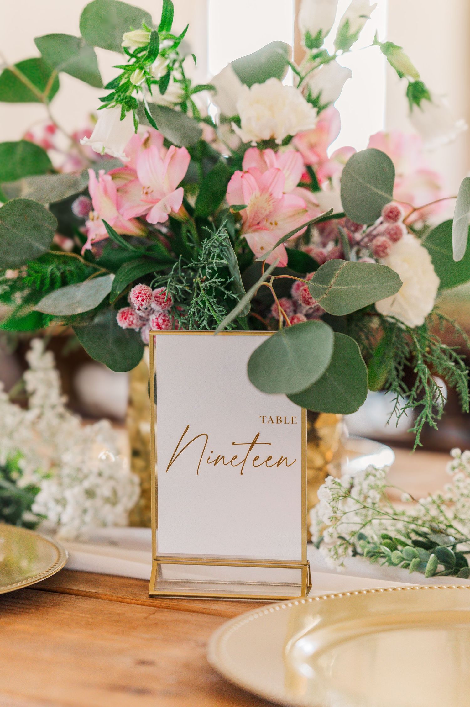 table nineteen sign sitting in front of flowers at the dinner table at a wedding