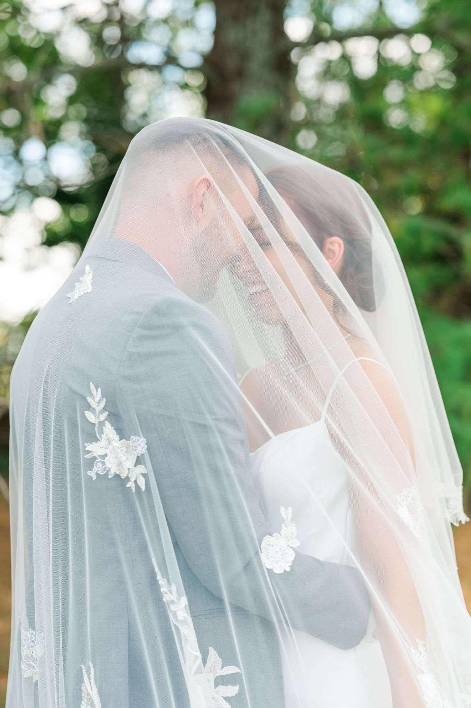 Bride and Groom under a veil with lace designs