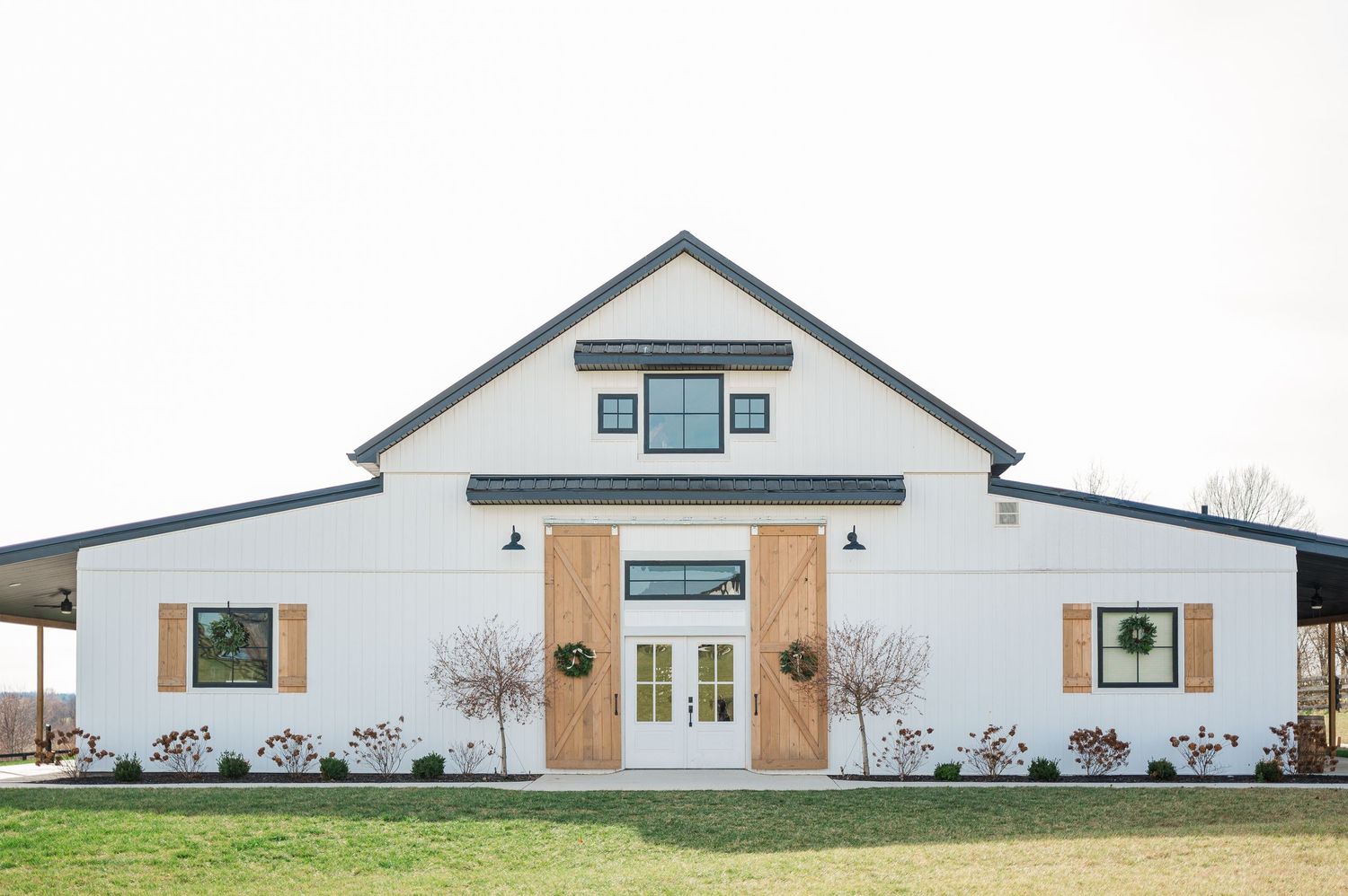 high end white barn venue in kentucky with brown shutters and black trimming