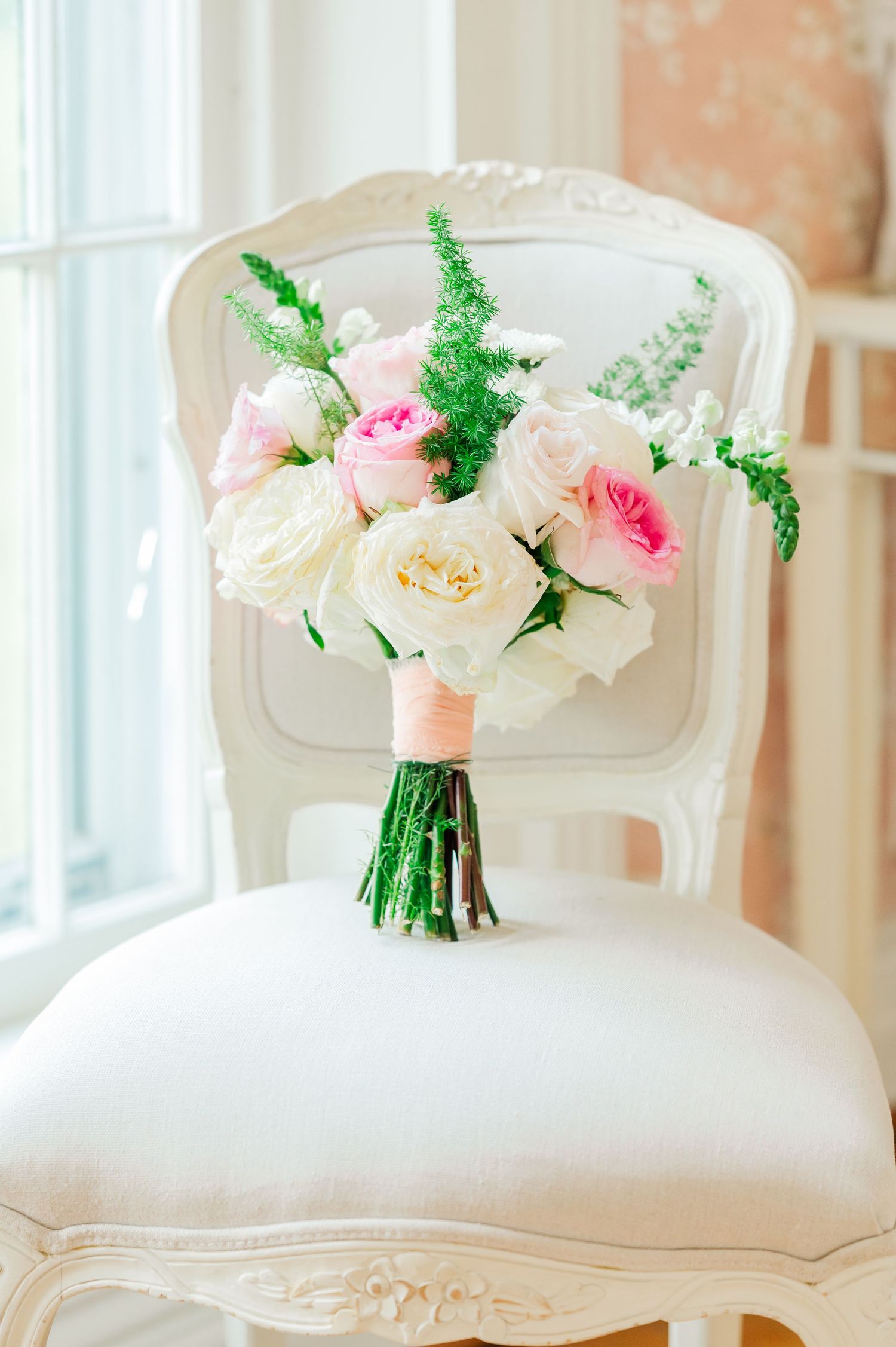 Wedding Bouquet sitting on a chair next to a window for a detail picture