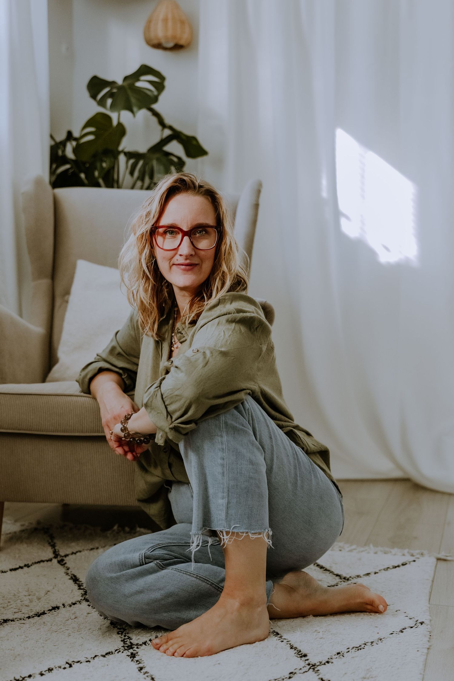 Casual lifestyle portrait in natural light with houseplant and woven pendant lamp decor.