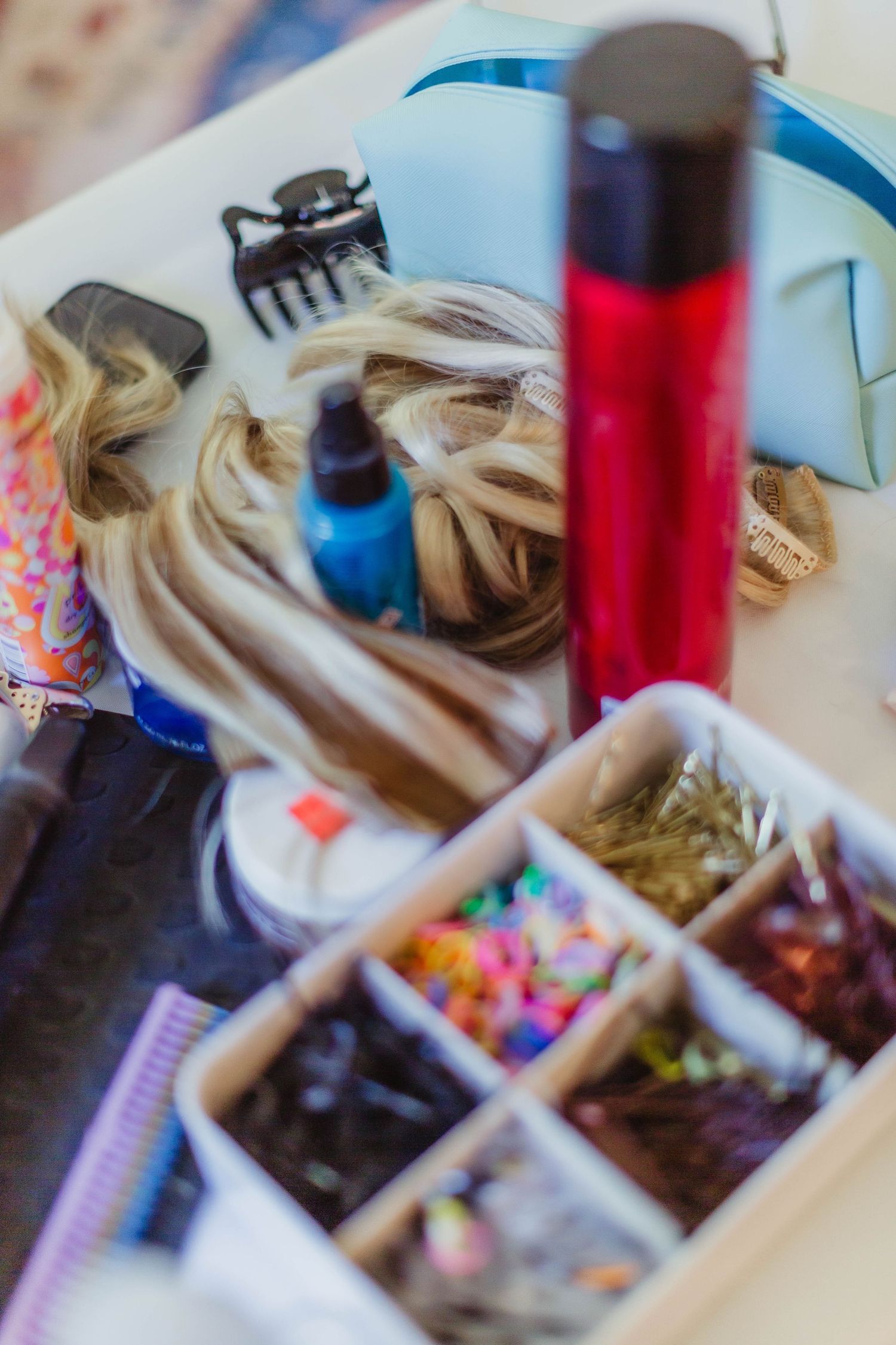 Hair styling tools and accessories arranged in compartments with colorful hair clips.