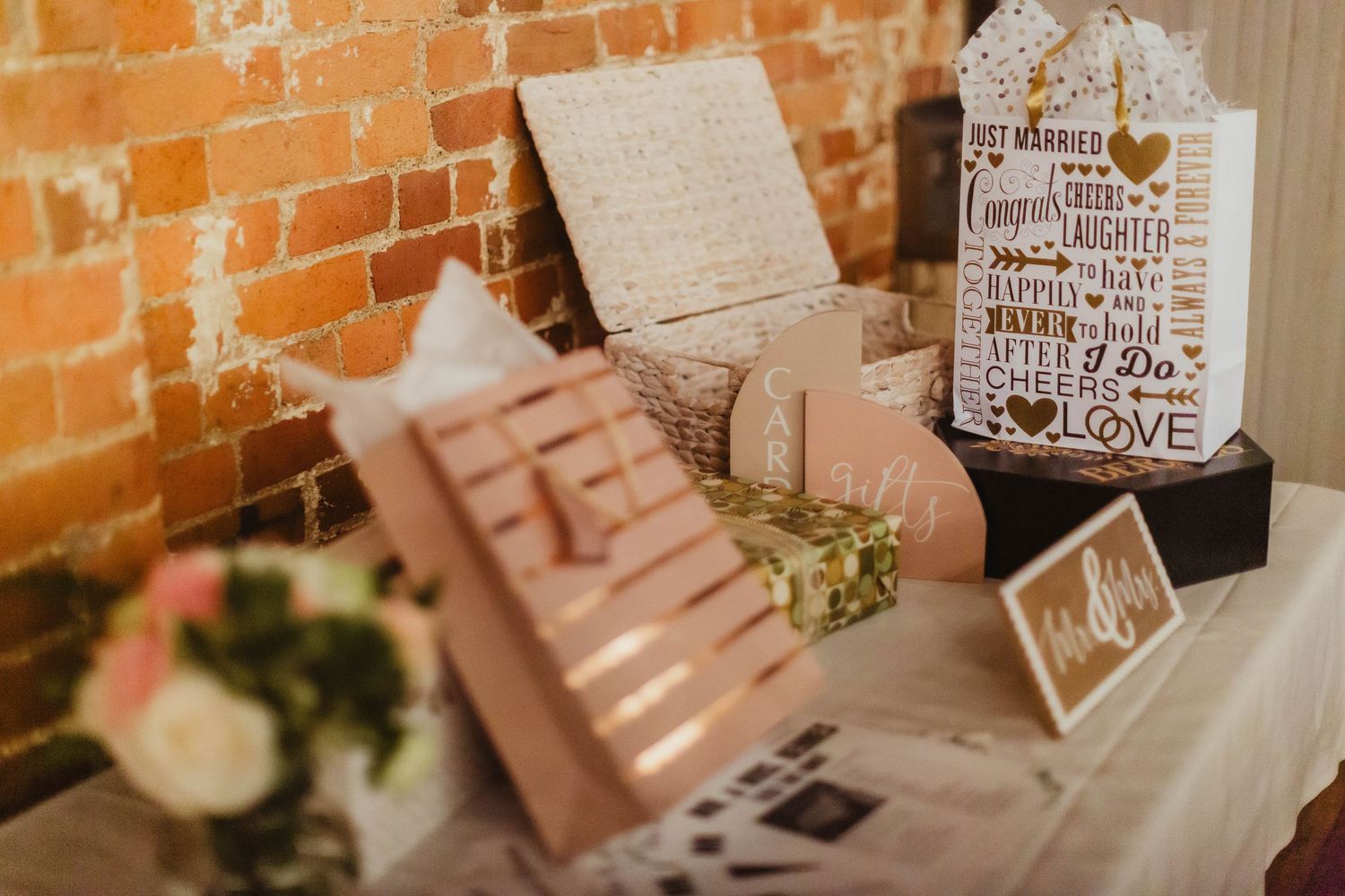 Wedding decor including rustic signs and frames against brick wall.
