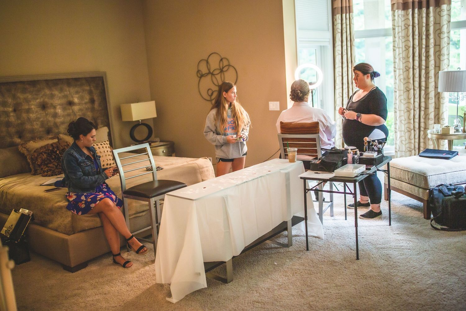 A group getting ready in a warm-toned room with stone accent wall and white table coverings.