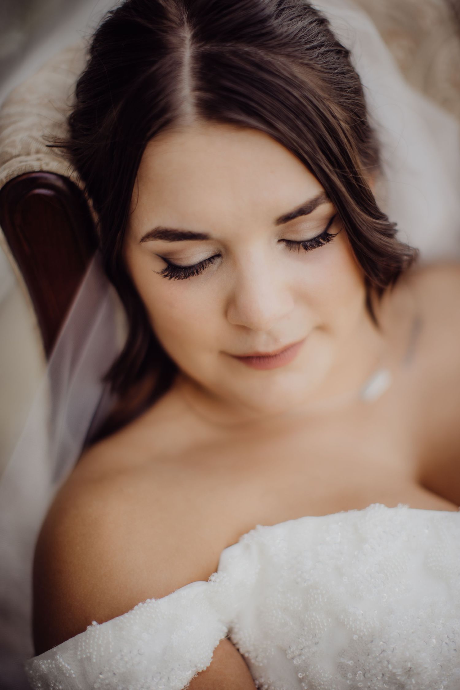 Dreamy close-up bridal portrait with soft makeup and delicate lace details.