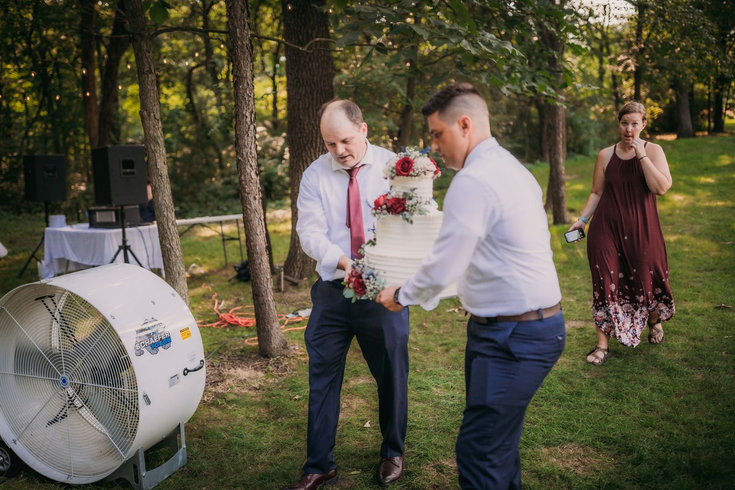 A behind-the-scenes photography setup with lighting equipment at an outdoor event in a wooded area.