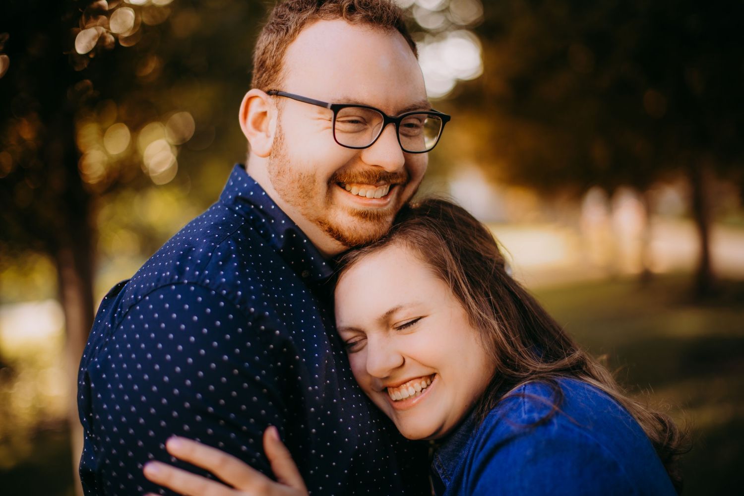 Close-up shot of a couple sharing joyful laughter in warm afternoon light.
