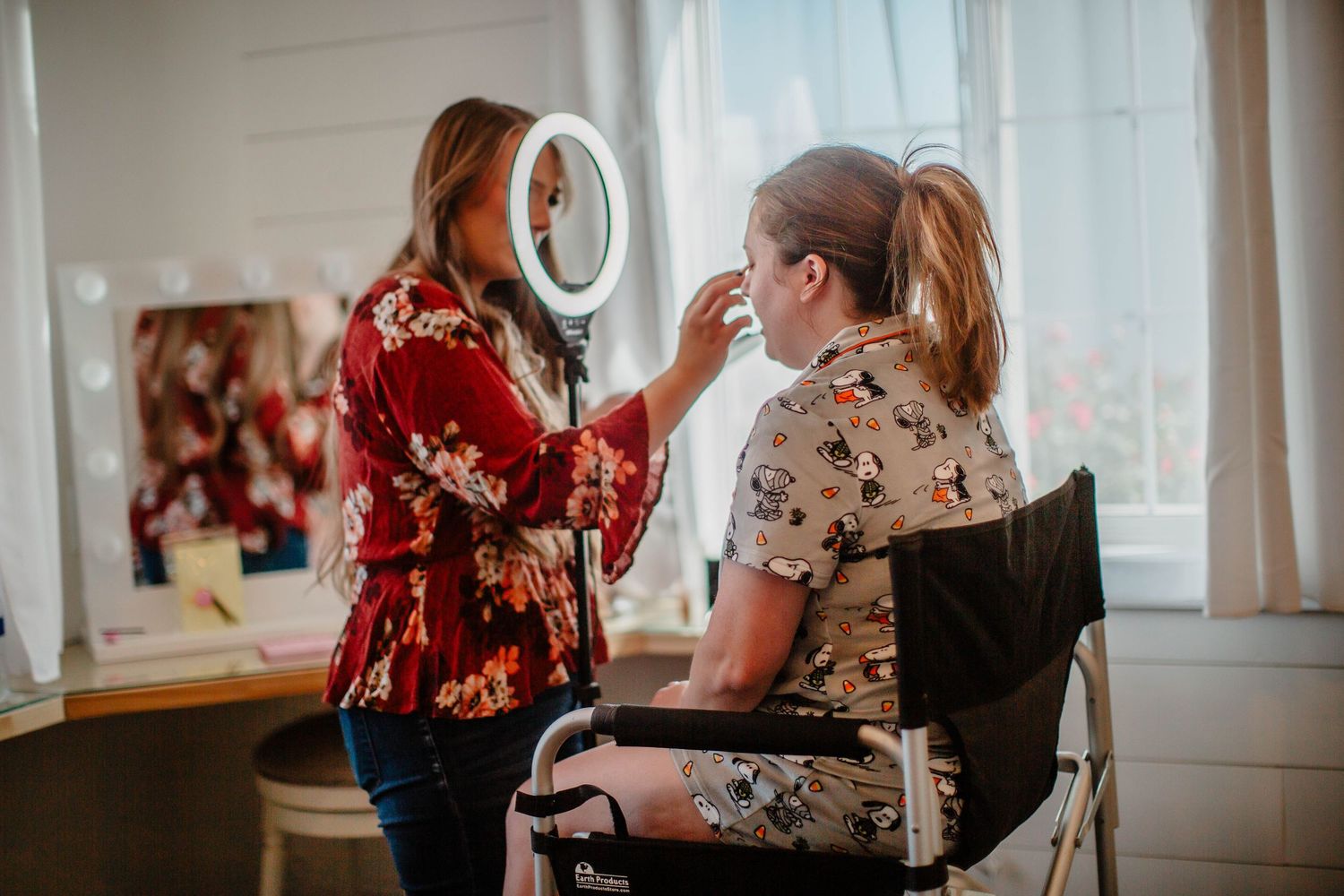 Makeup artist signing documents at a wooden desk.