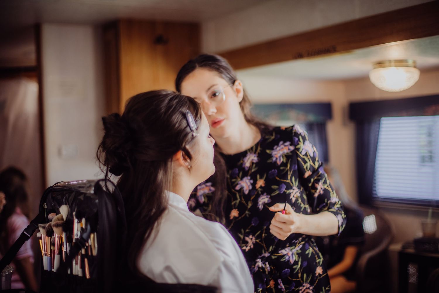 Wedding preparation moment in an indoor setting with soft lighting.