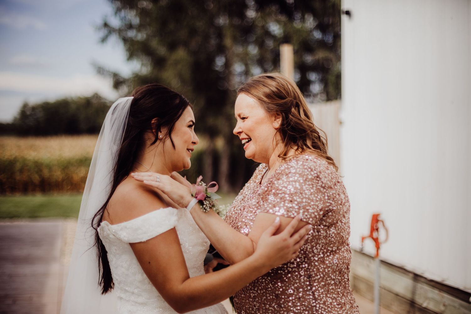 Two wedding attendees share an emotional moment of joy and laughter.