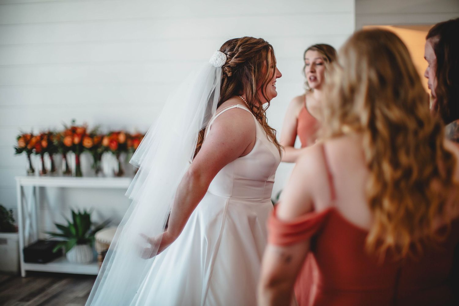 Wedding party members share tender embraces in a light-filled room on the big day.