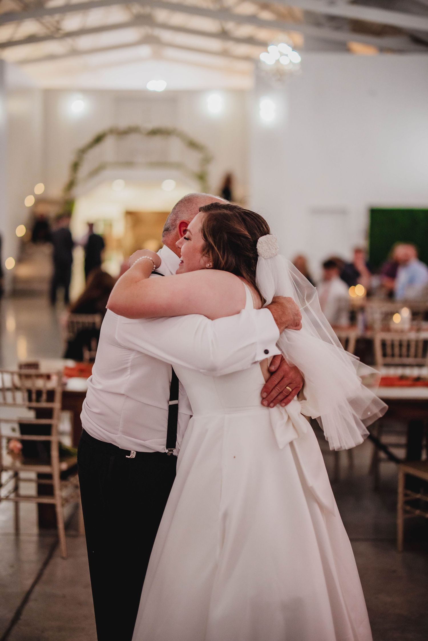 A heartfelt embrace during a wedding reception dance between a bride and her partner.