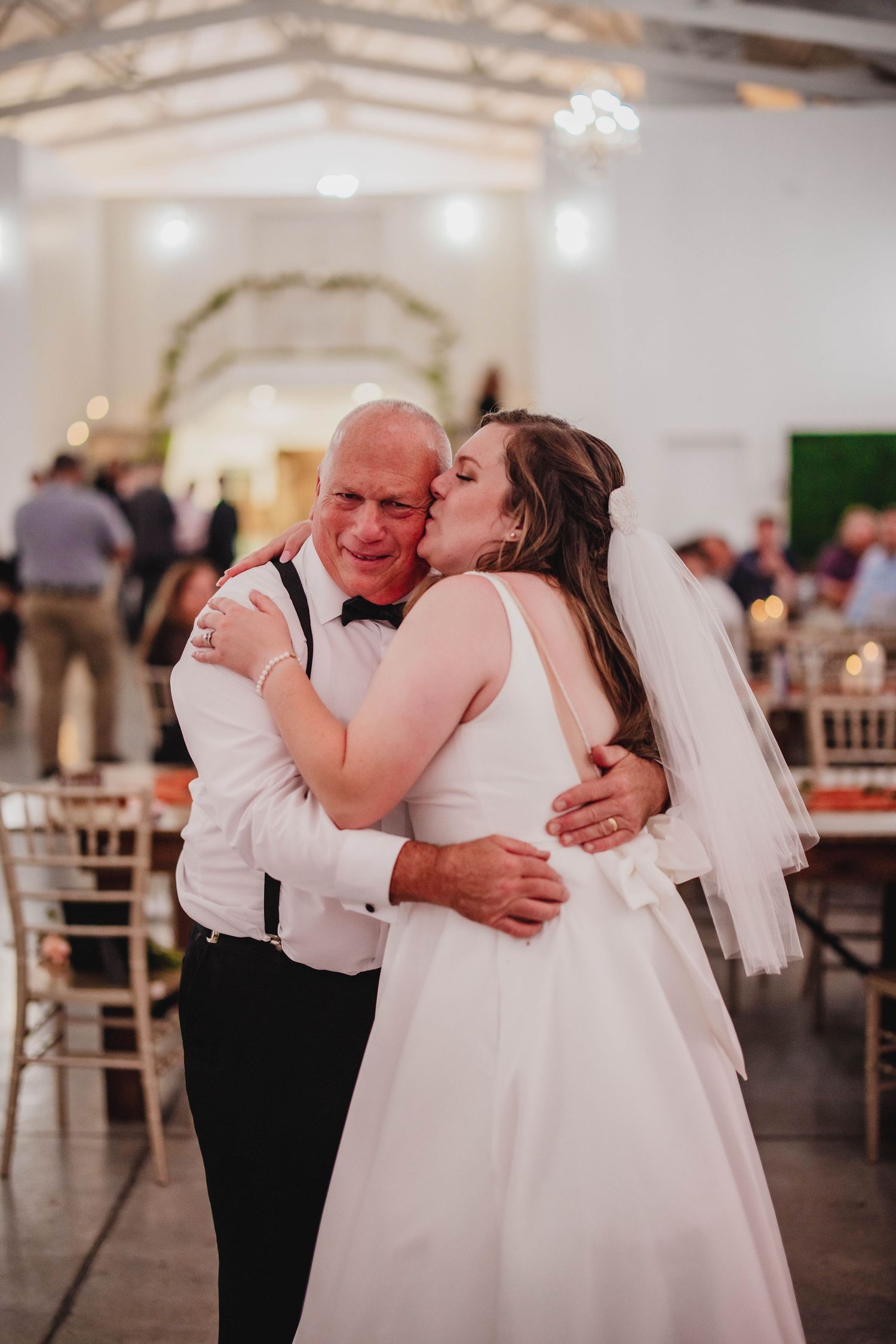 An emotional dance embrace captured during a wedding reception in an elegant venue.