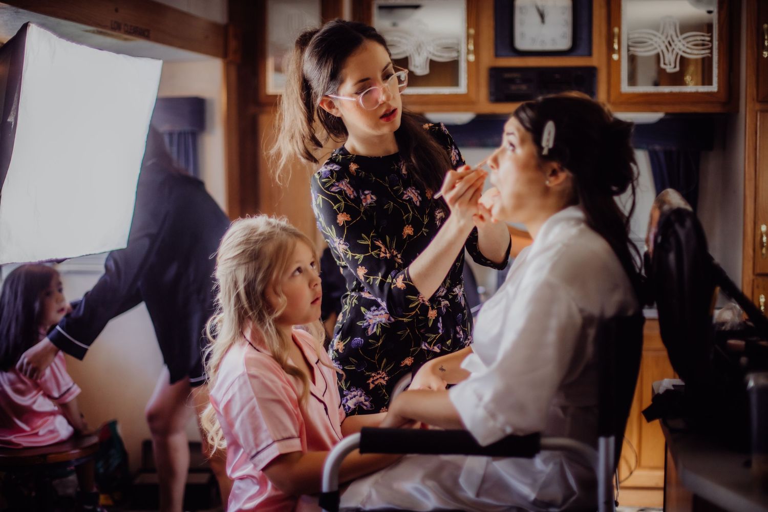 Wedding preparation scene with makeup artist working in a rustic room.