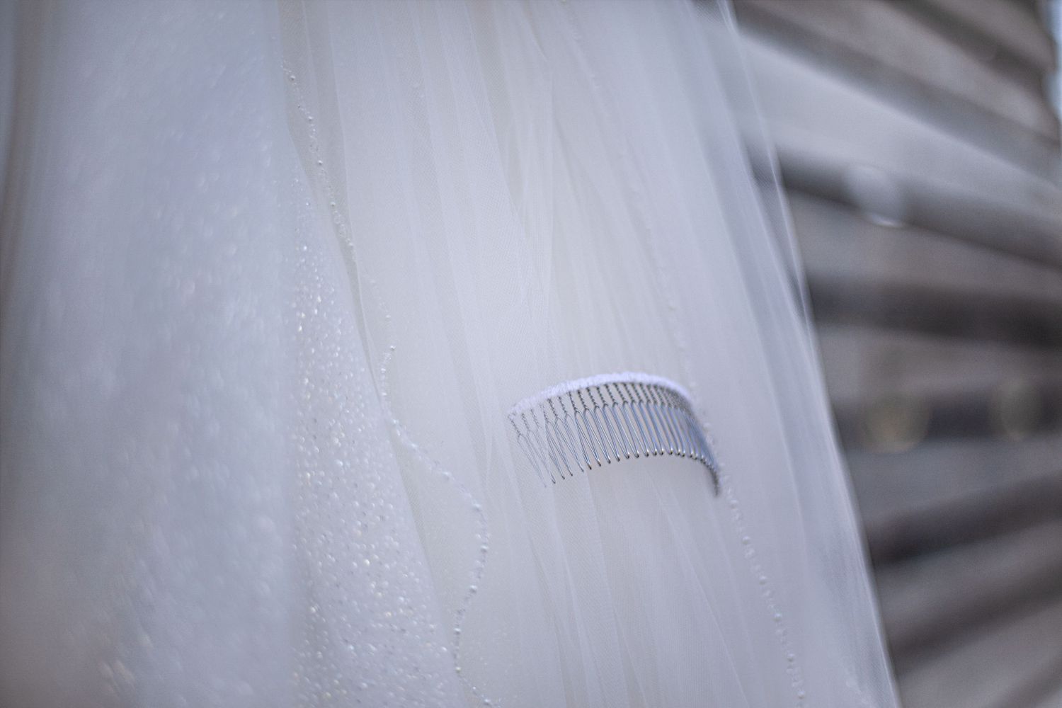 Small decorative comb accessory against white tulle fabric.
