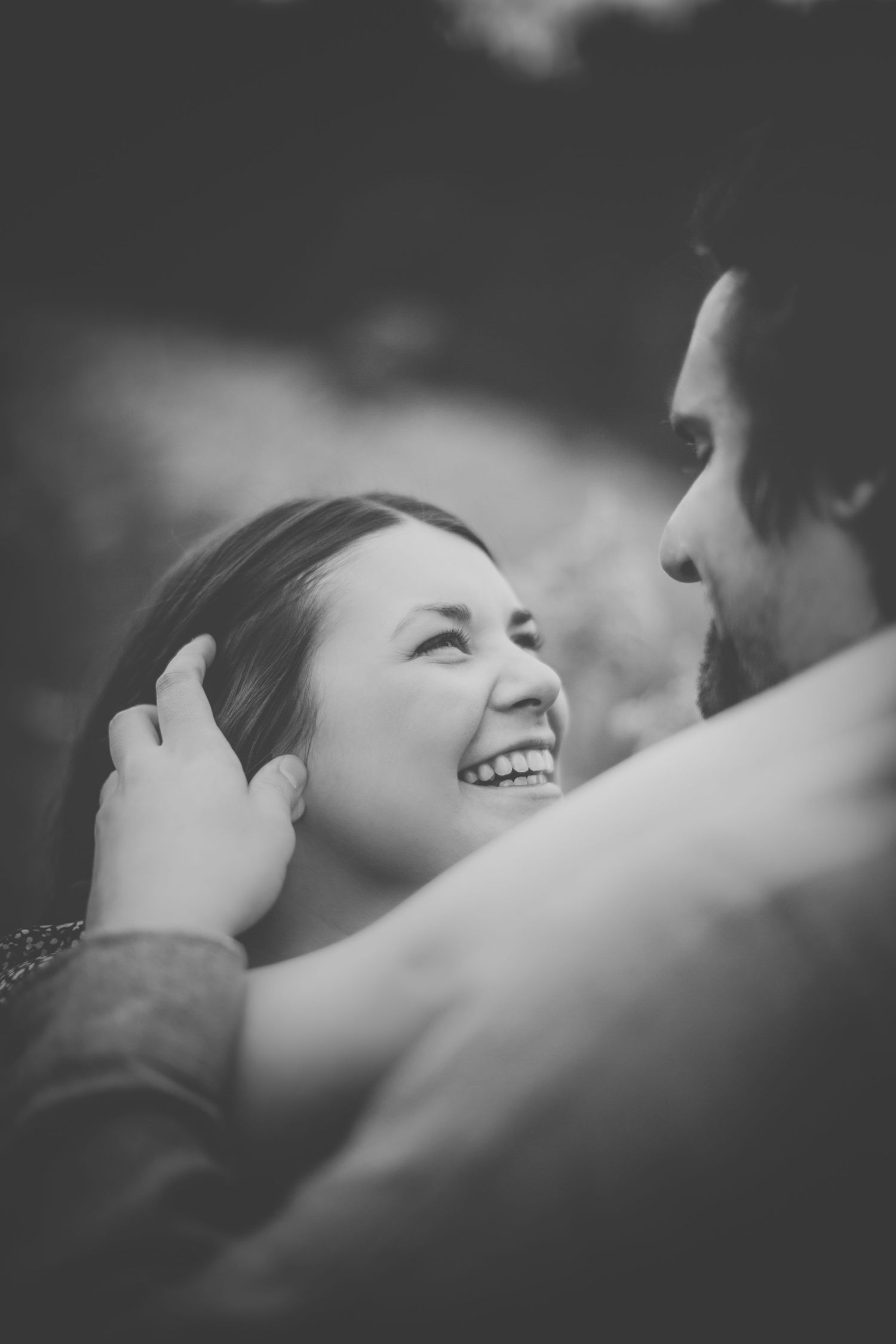 Black and white intimate portrait of a couple laughing together.