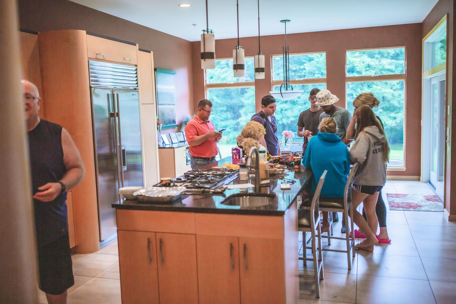 People gather around a modern kitchen island during a pre-wedding celebration.