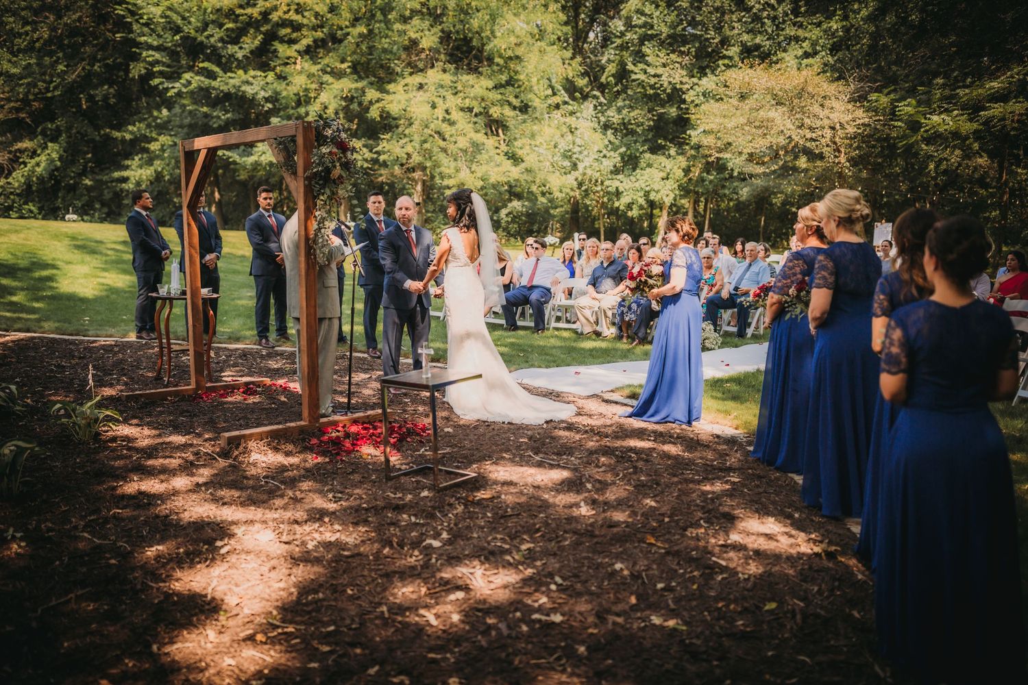 Beautiful outdoor wedding venue with natural woodland setting and rows of white ceremony chairs.