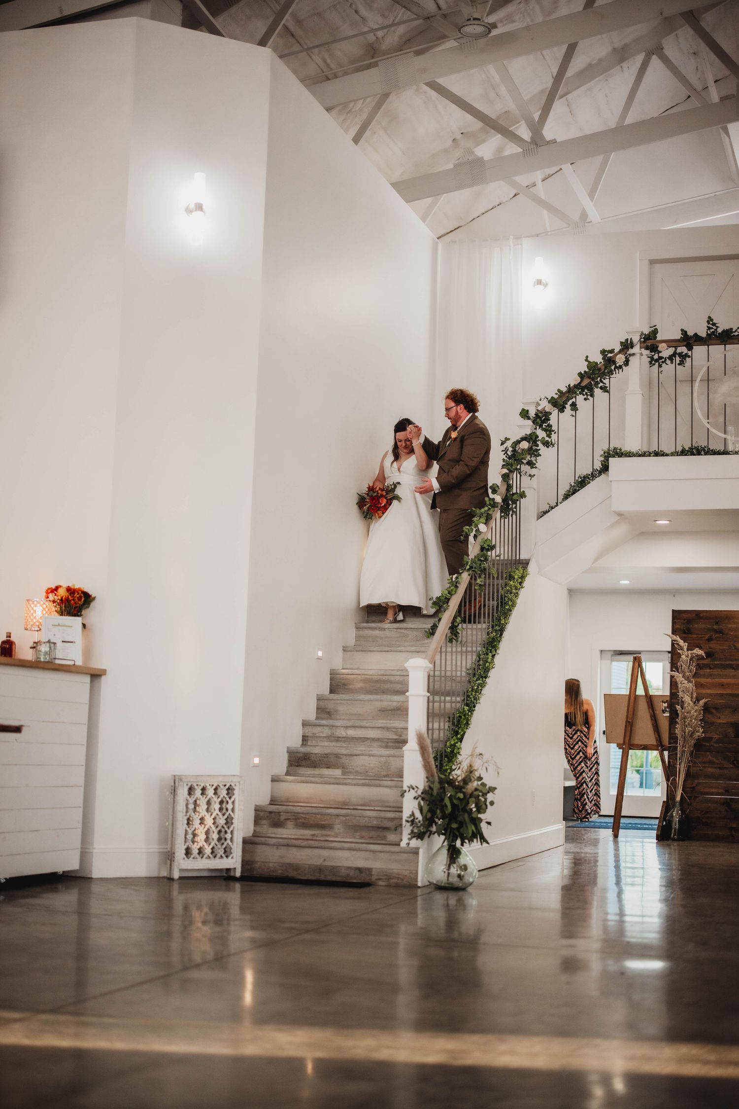 Interior shot of modern white wedding venue with concrete stairs and rustic wooden accent wall.