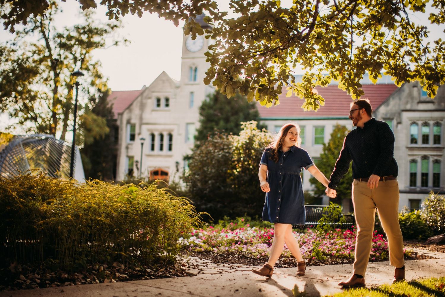 Couple shares a romantic moment in a park during golden hour sunset.
