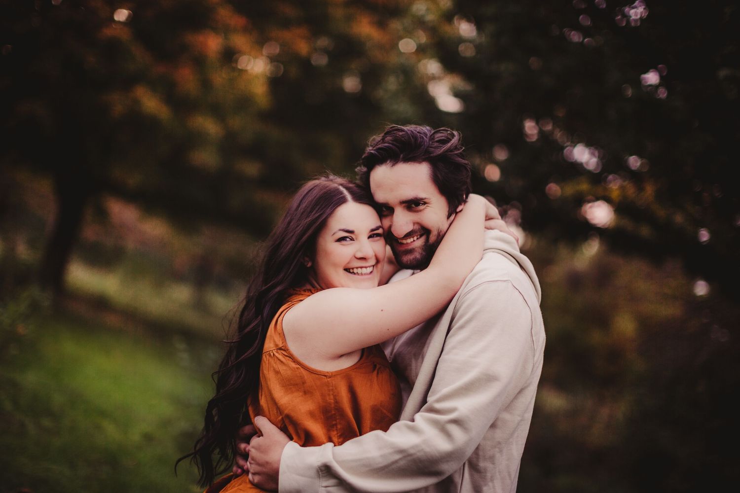 Candid romantic moment captured outdoors with bokeh lighting effects.