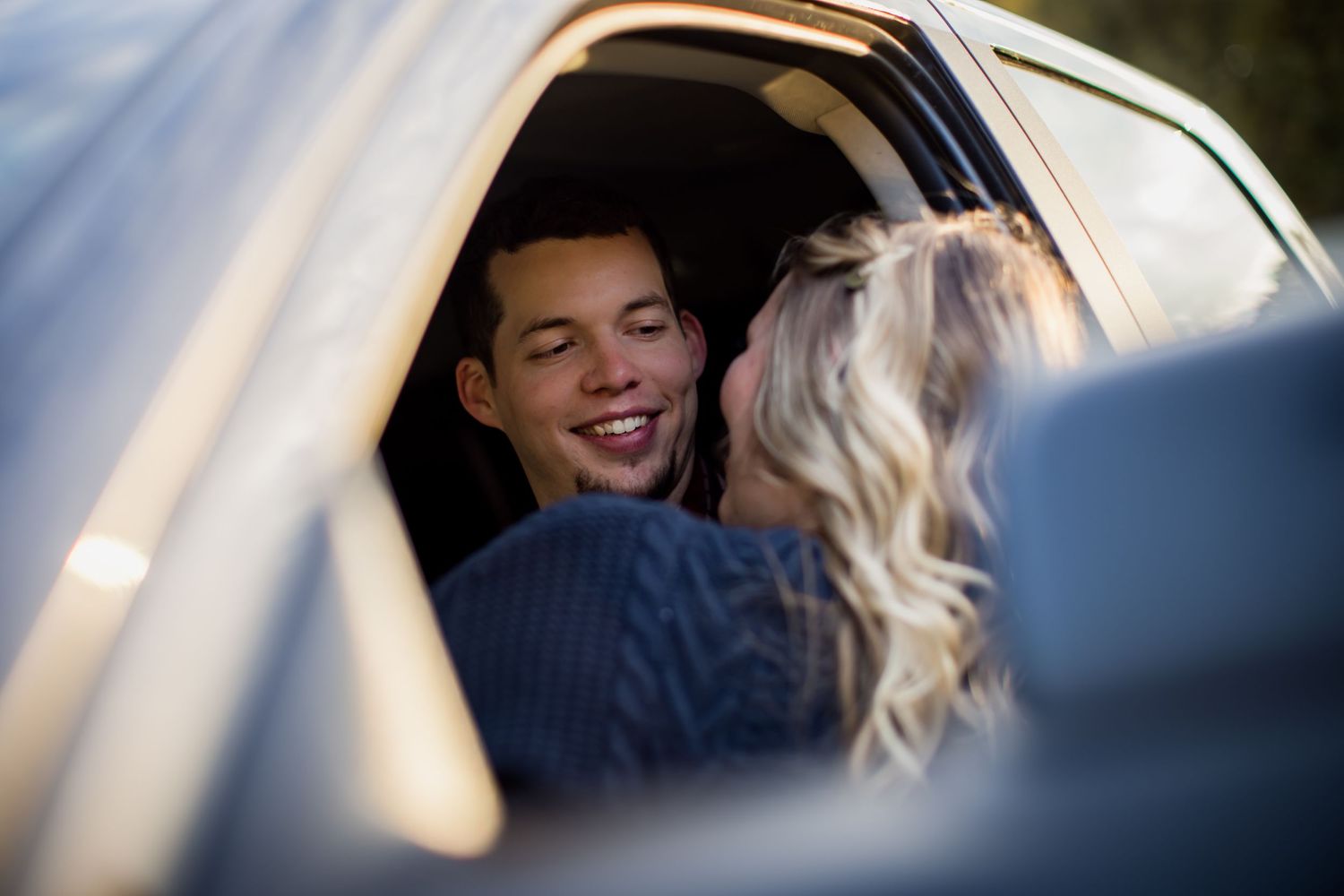 Romantic couple moment captured through a car window.