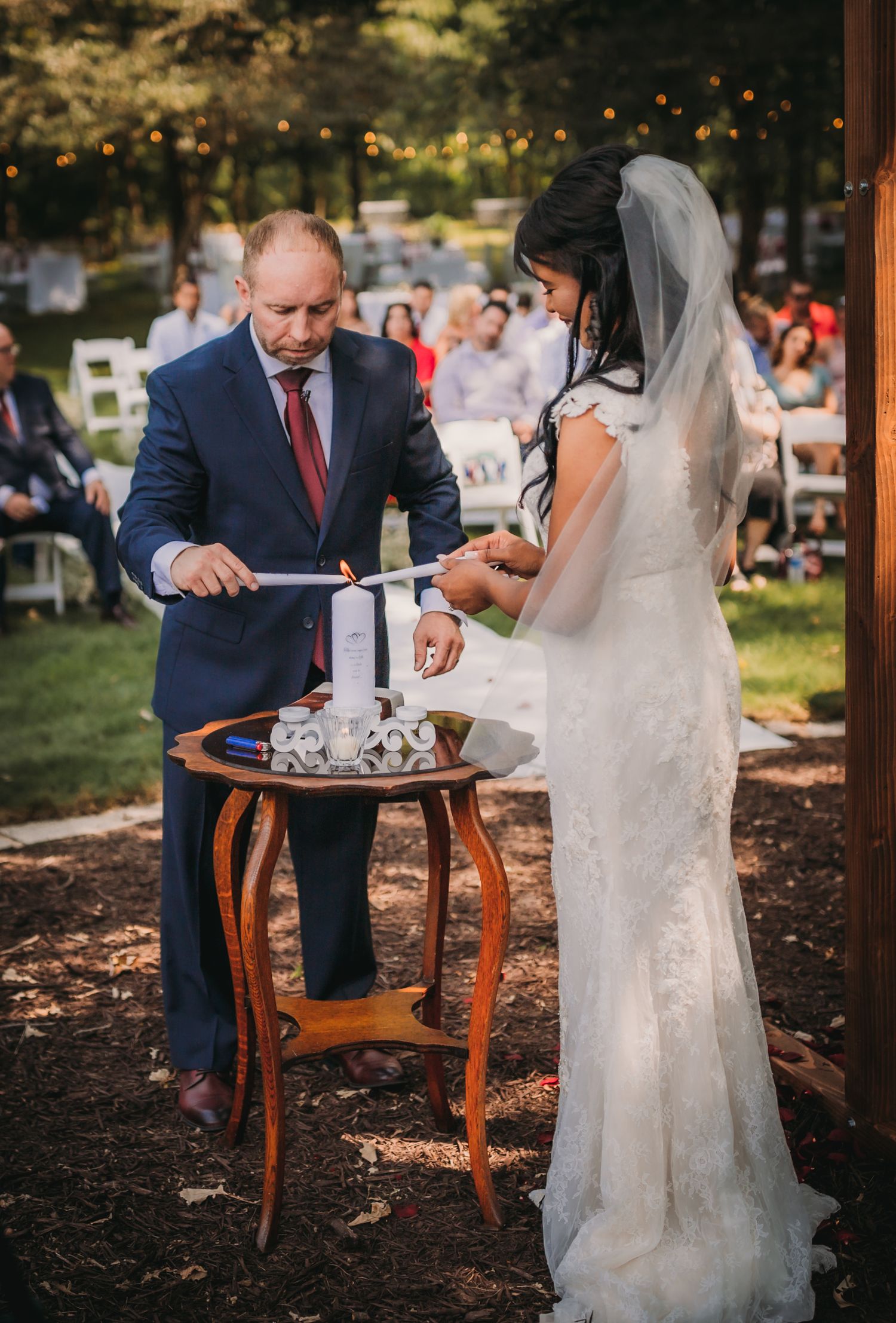 Wedding ceremony signing moment under wooden pergola with vintage furniture.