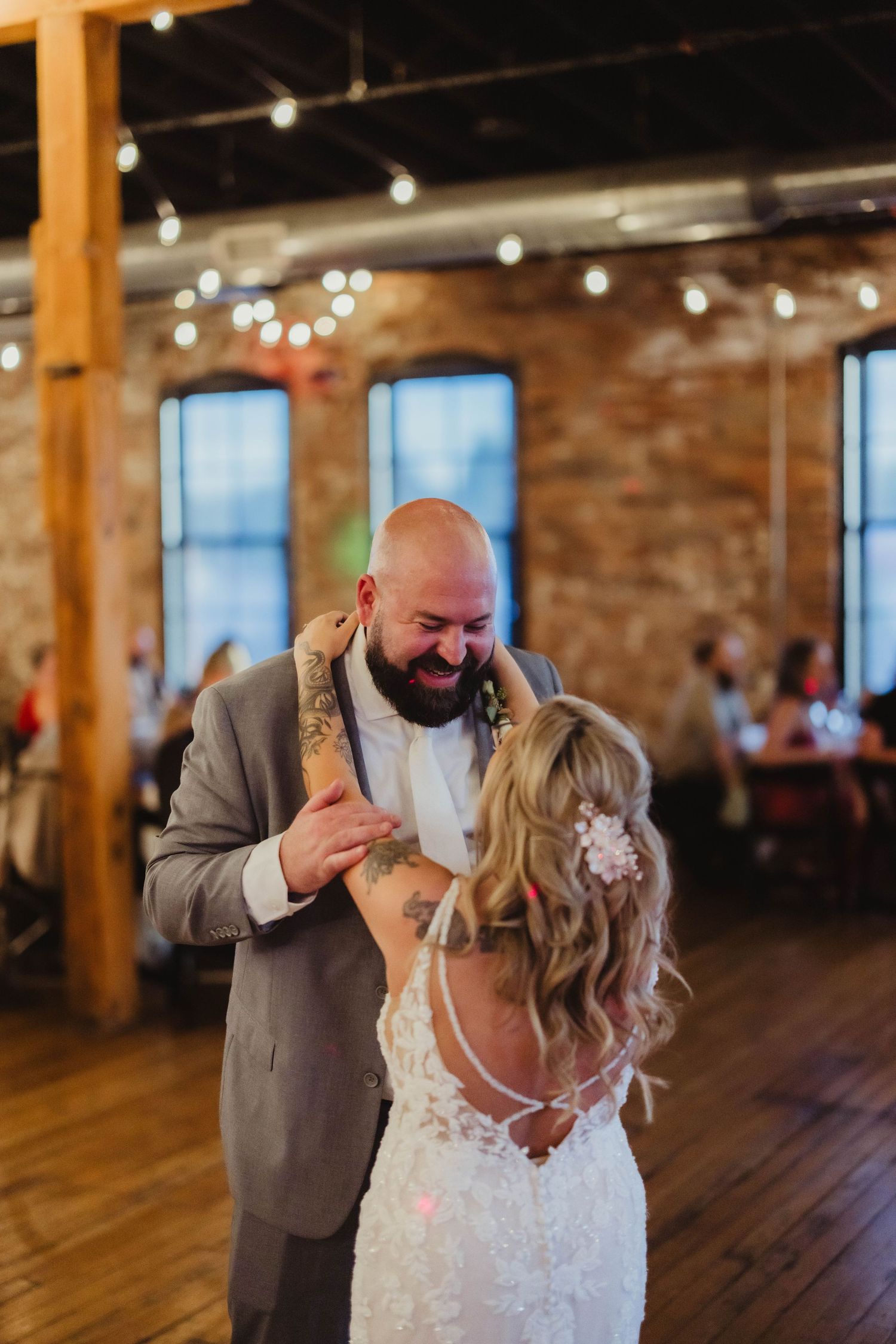 Emotional first dance moment captured at rustic wedding reception venue.