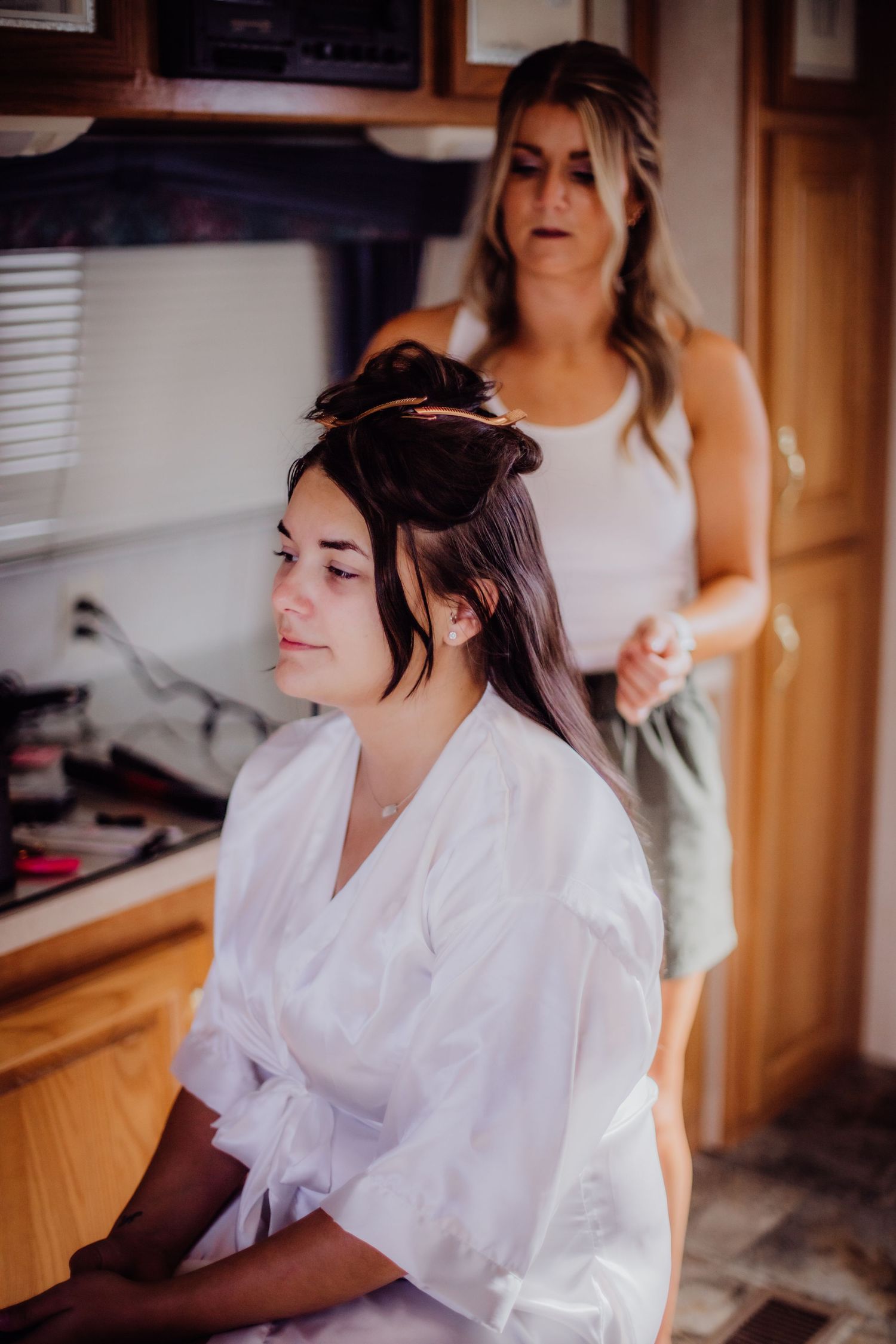 Wedding preparations scene showing people in white robes getting ready in an indoor setting.