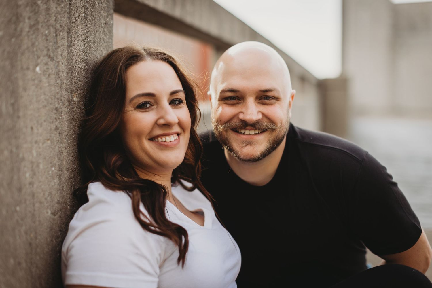 A couple shares playful moments during an urban photoshoot.