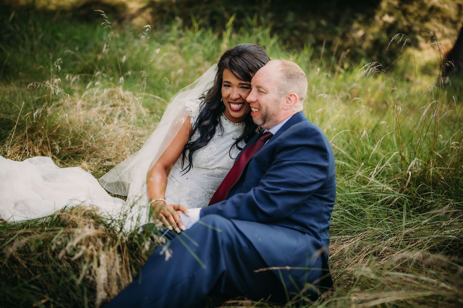 Intimate wedding portrait showing genuine laughter and connection in a natural outdoor setting.