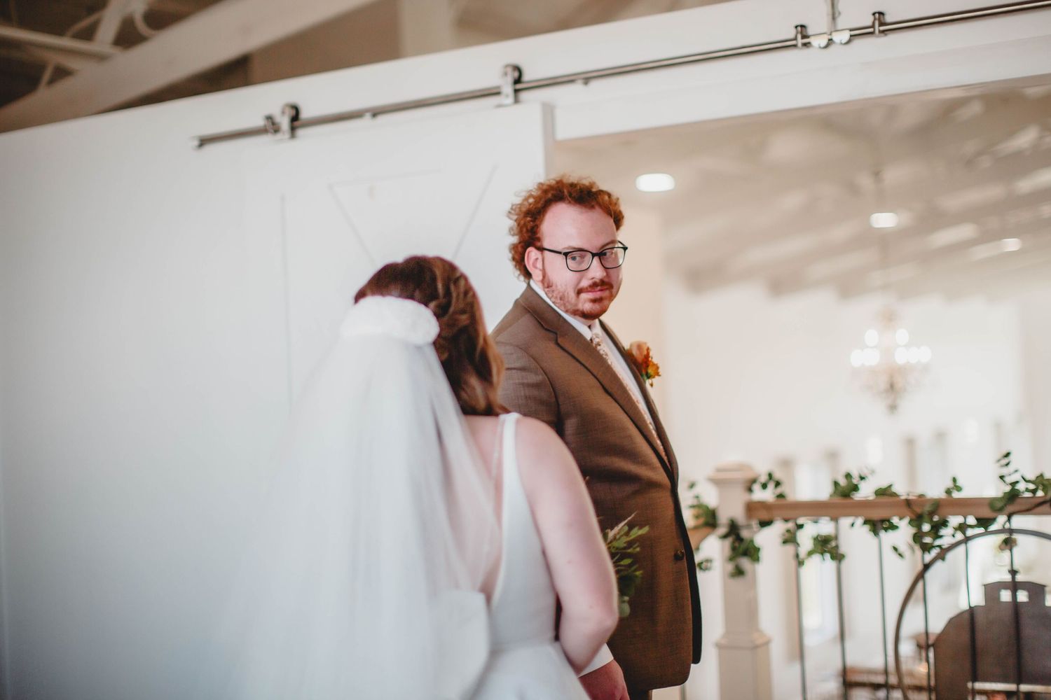 An indoor wedding ceremony space with exposed beams and decorative lighting fixtures.
