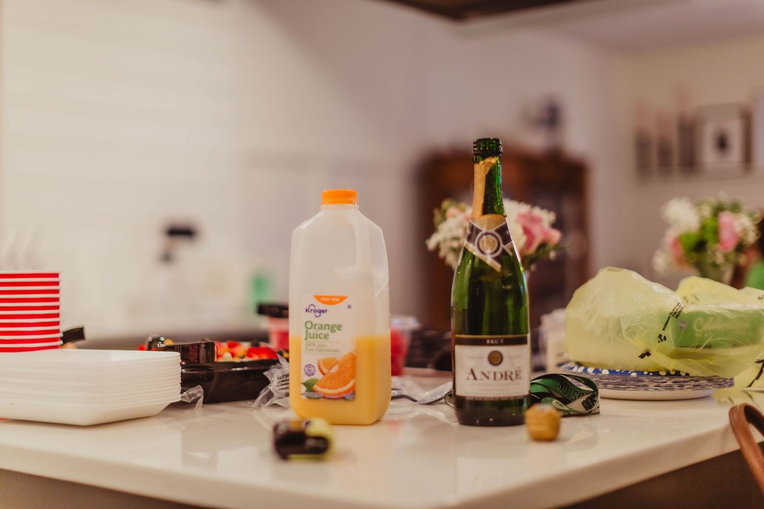 Wedding preparation setup with orange juice and champagne bottle on counter.