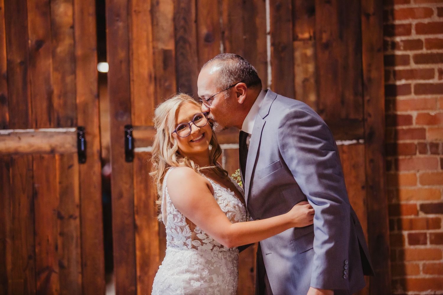 A tender moment captured between newlyweds against a rustic wooden backdrop.