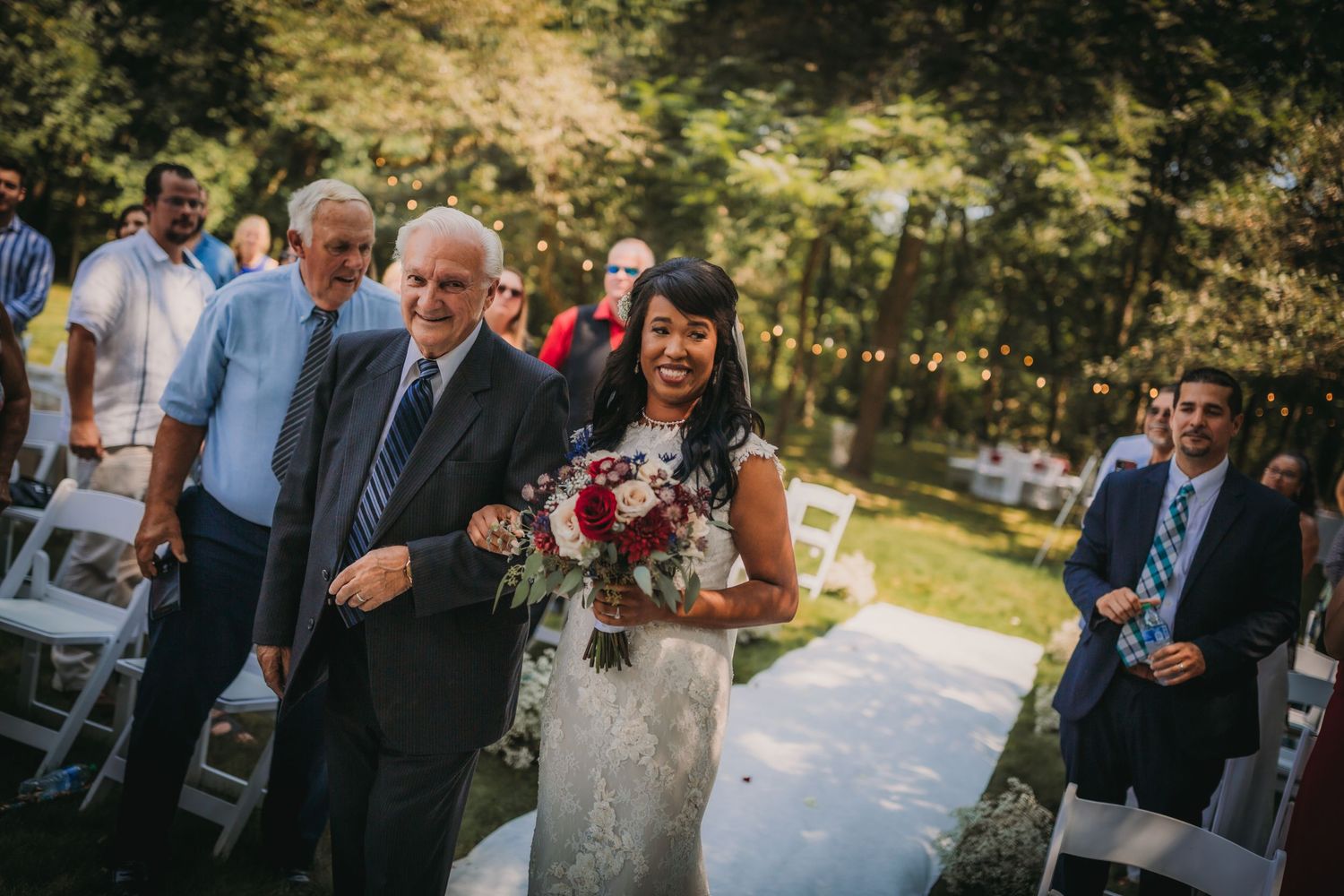 Wedding guests mingling during an outdoor garden reception under natural shade.