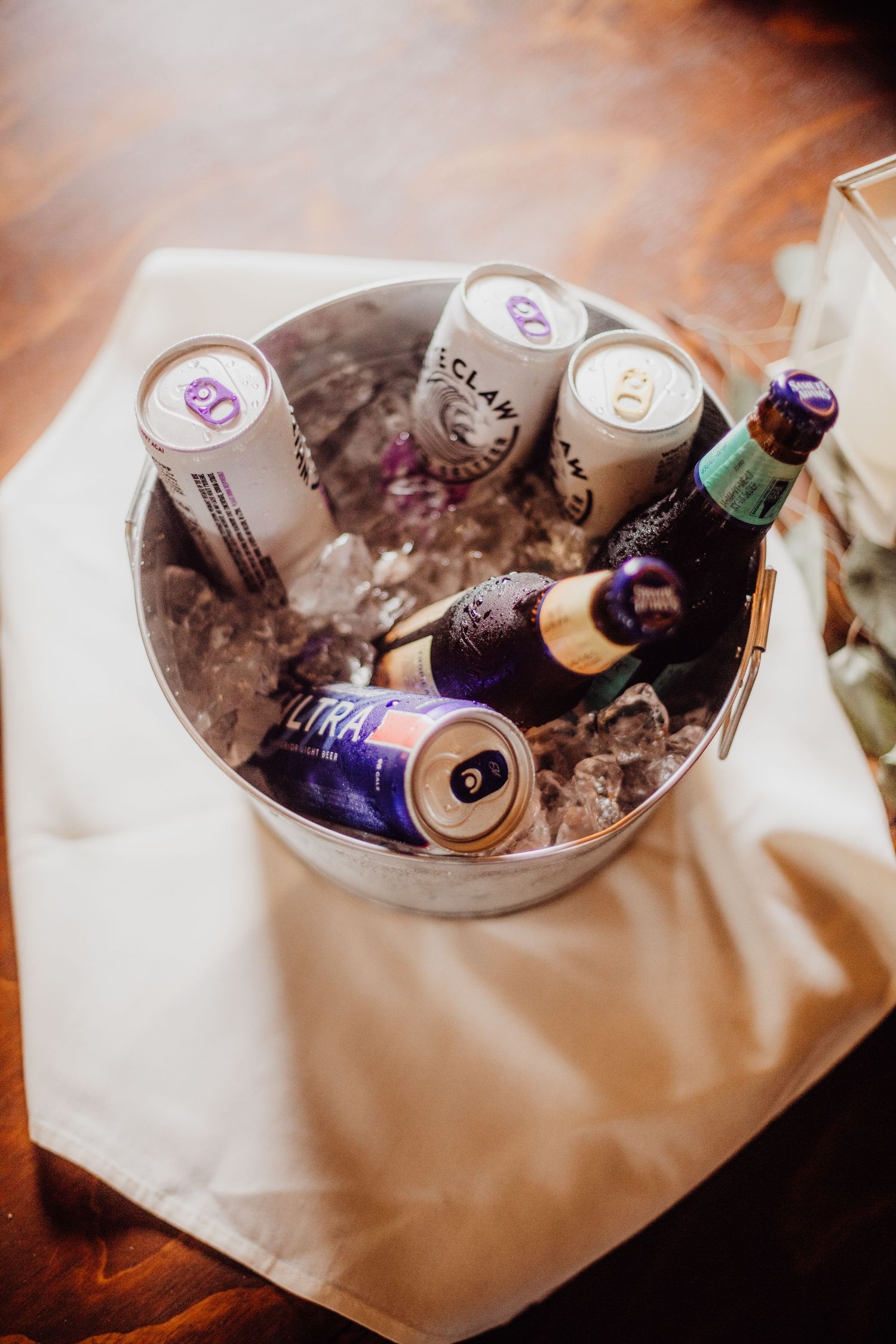 Ice-filled bucket with assorted beverages chilling at a wedding reception.