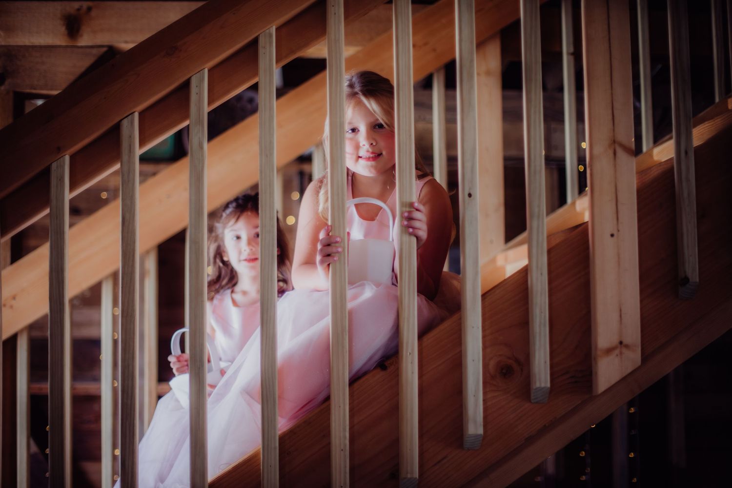 Guests watching from a wooden staircase during a wedding ceremony.