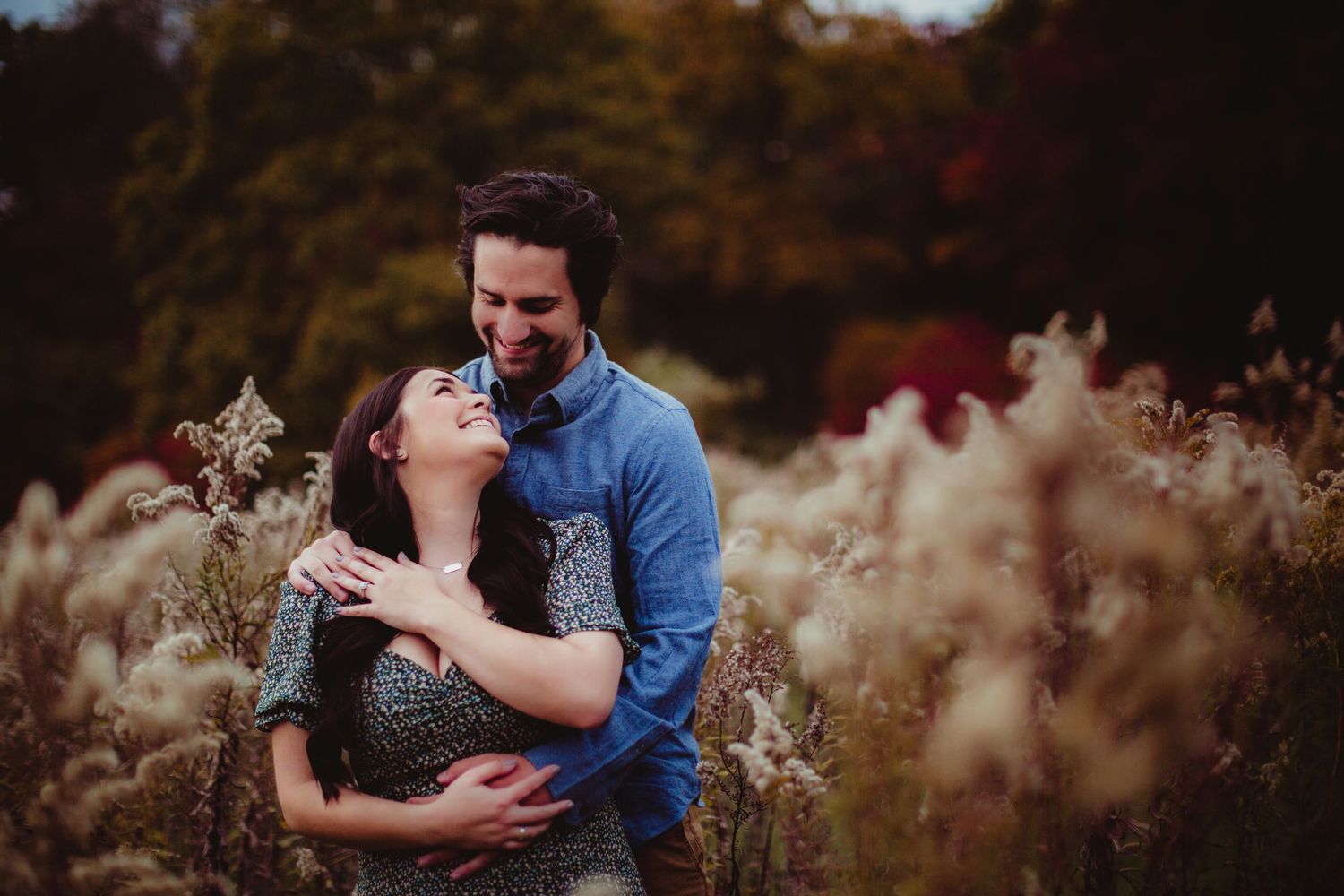 Intimate moment between couple photographed in natural autumn setting.
