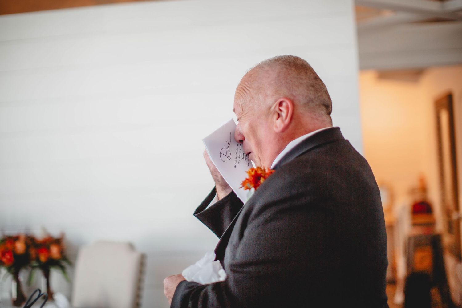 Someone in formal attire reads a heartfelt note during an intimate wedding ceremony.