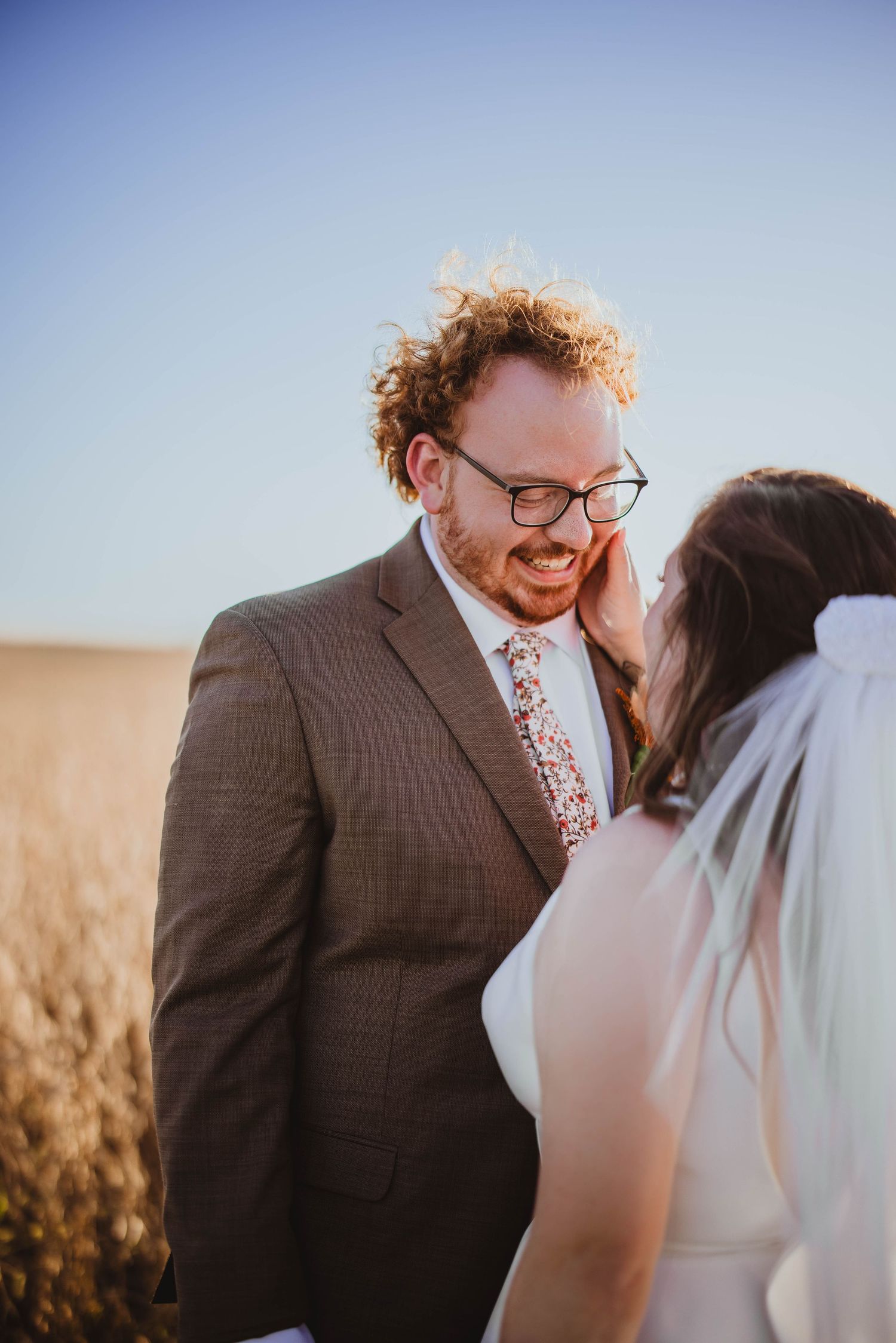 Close-up wedding portrait of couple sharing laughter in golden afternoon light.
